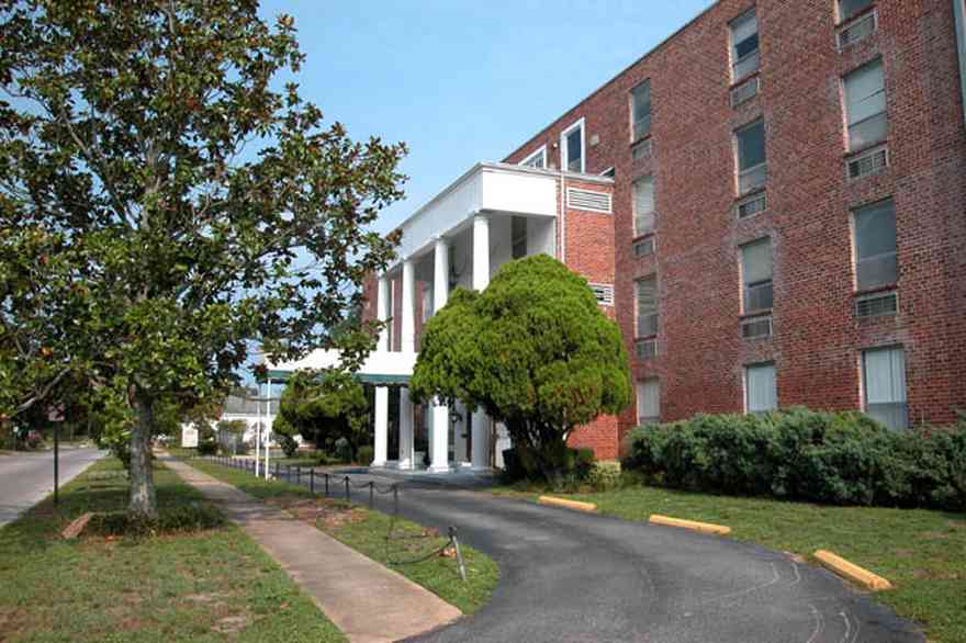 Belmont-Devillers:-The-Magnolias_01a.jpg:  magnolia tree, fir tree, columns, brick building, nursing home, apartment building, 
