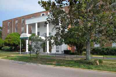 Belmont-Devillers:-The-Magnolias_02.jpg Belmont-Devillers:-The-Magnolias_02.jpg: magnolia tree, fir tree, columns, brick building, nursing home, apartment building,