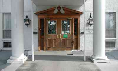 Belmont-Devillers:-The-Magnolias_07.jpg:  magnolia tree, fir tree, columns, brick building, nursing home, apartment building, , 