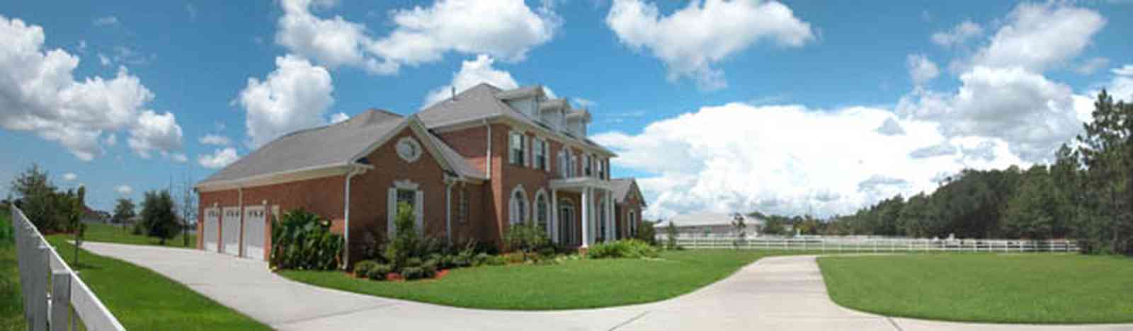Cantonment:-Milestone:-Red-Brick-Mansion-A_03.jpg:  columns, dormer windows, shutters, circular driveway, white board fence, red brick mansion, subdivision