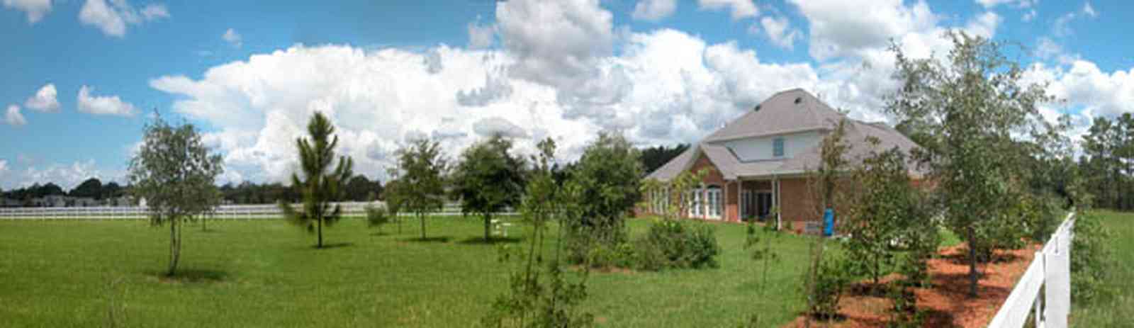 Cantonment:-Milestone:-Red-Brick-Mansion-A_04.jpg:  columns, dormer windows, shutters, circular driveway, white board fence, red brick mansion, subdivision