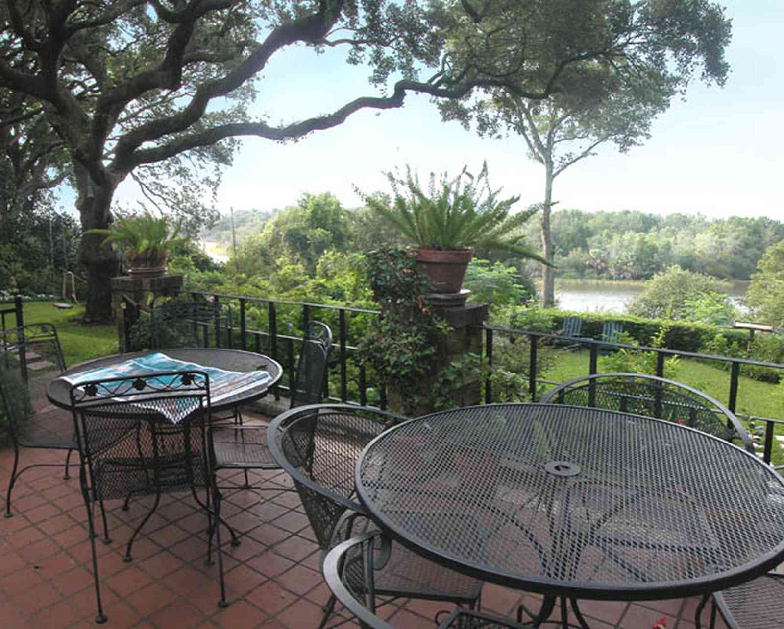 East-Hill:-1801-East-La-Rua-Street_06.jpg:  patio, wrought-iron tables, wrought-iron chairs, ferns, terrezzo tiles