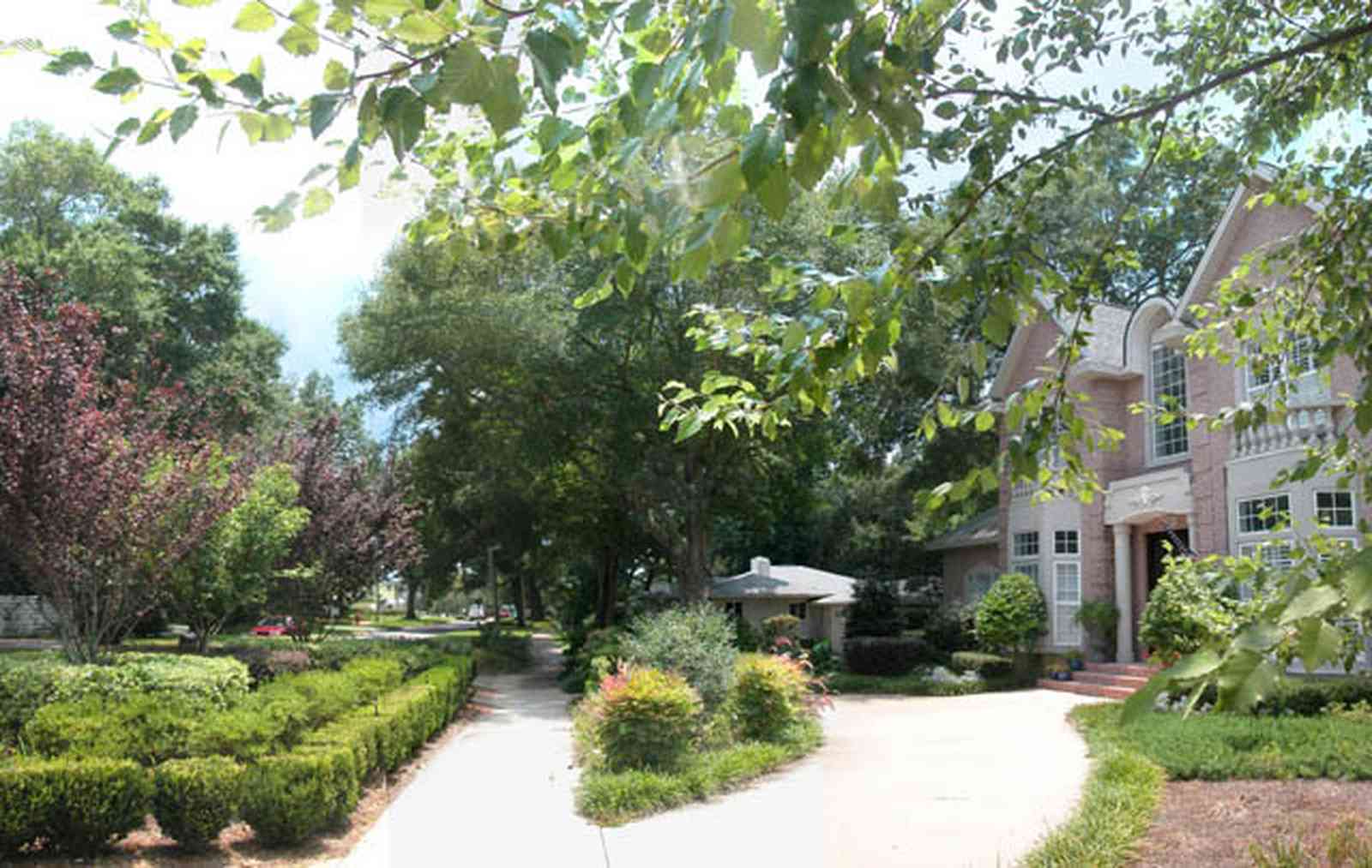 East-Hill:-617-19th-Avenue_06.jpg:  circular driveway, pink brick house, columns, bay windows, balustrade, boxwood hedge