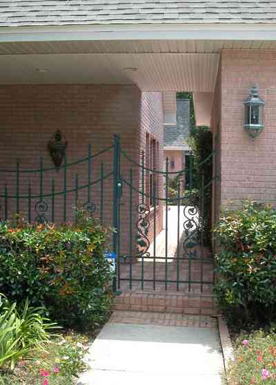 East-Hill:-617-19th-Avenue_09.jpg:  wrought-iron gate, pink brick house, side entrance