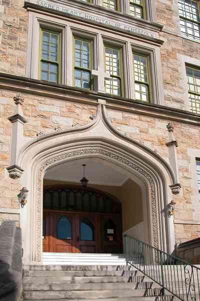 East-Hill:-Tower-East:-Old-Sacred-Heart-Hospital_02a.jpg:  gothic revival architecture, stairs, casement windows, masonry facade, battlement,pediment