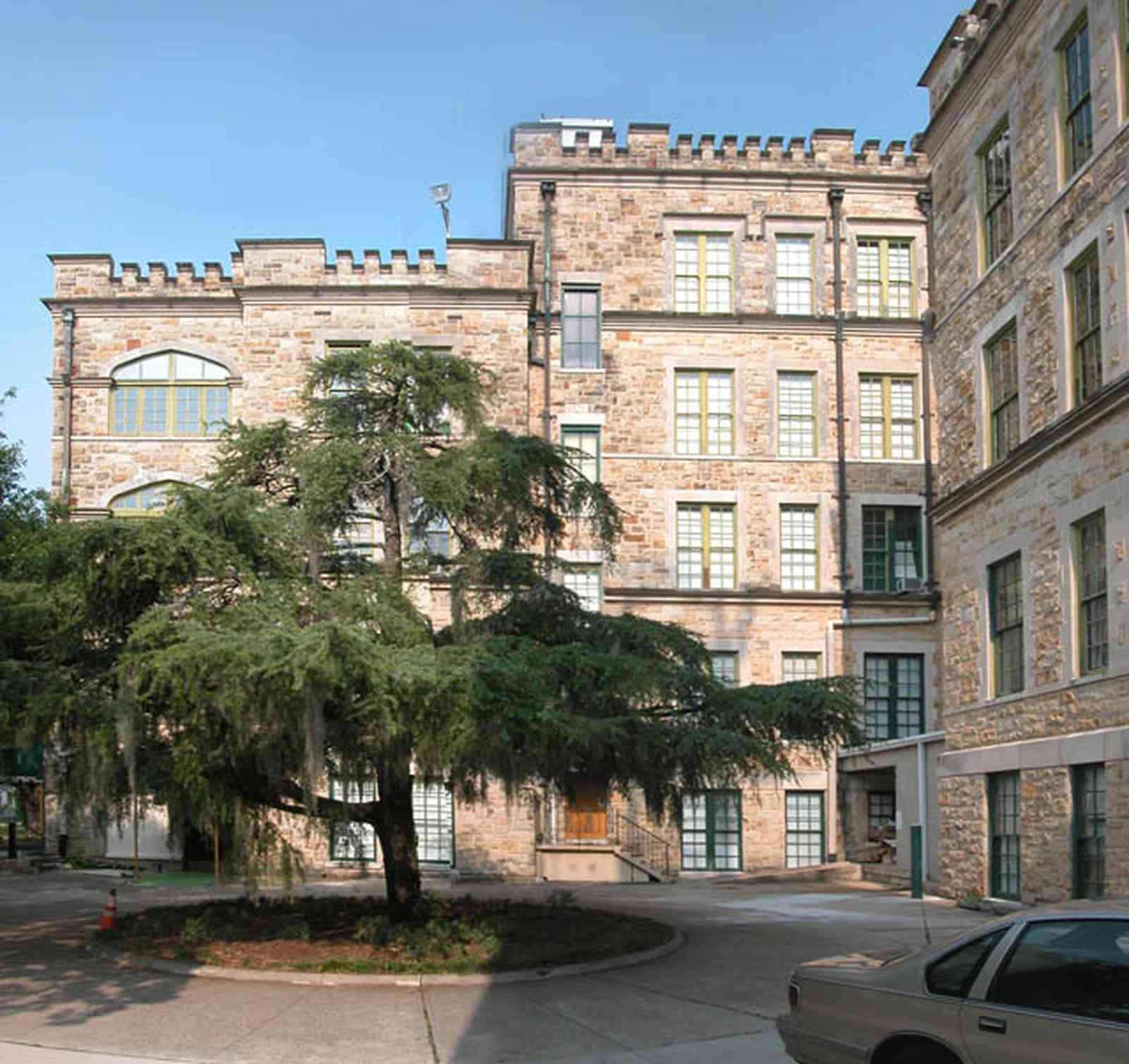 East-Hill:-Tower-East:-Old-Sacred-Heart-Hospital_20a.jpg:  fir tree, stone battlements, entrance patio, hospital