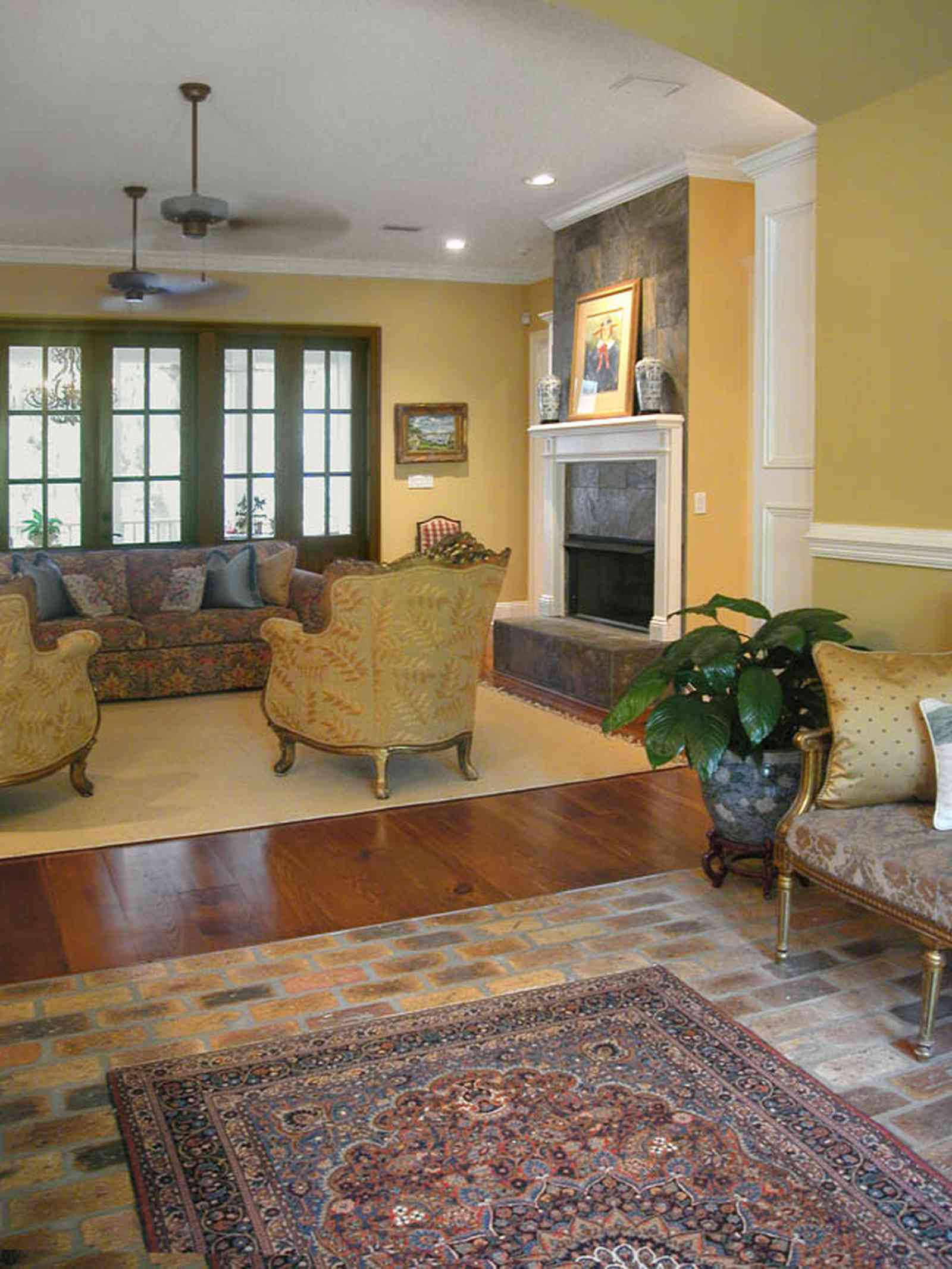 East-Pensacola-Heights:-112-Chipley-Avenue_05.jpg:  brick floor, oriental rug, brocade fabric, ceiling fan, divided panes, heart-pine floor