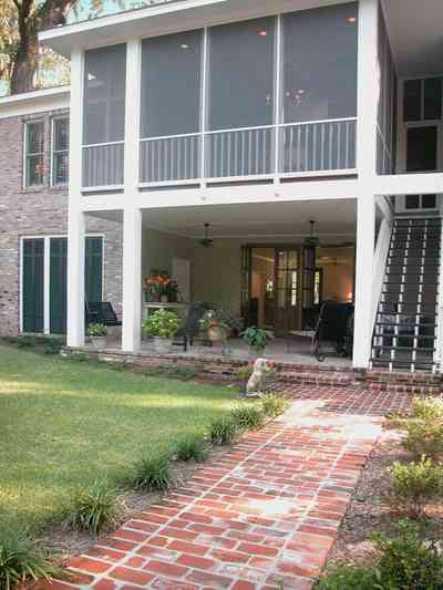 East-Pensacola-Heights:-112-Chipley-Avenue_21.jpg:  brick sidewalk, rear staircase, patio, veranda, shutters, brick facade, screen porch, columns