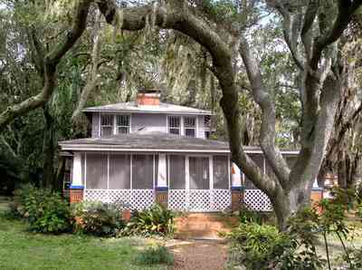 East-Pensacola-Heights:-600-Bayou-Blvd_02.jpg:  bungalow, live oak trees, spanish moss, lattice trim, brick pillars, brick sidewalk, fireplace, bayou view