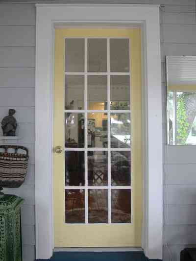 East-Pensacola-Heights:-600-Bayou-Blvd_06.jpg:  front door, front porch, french door, pine lap siding, wicker basket, bayou, cottage