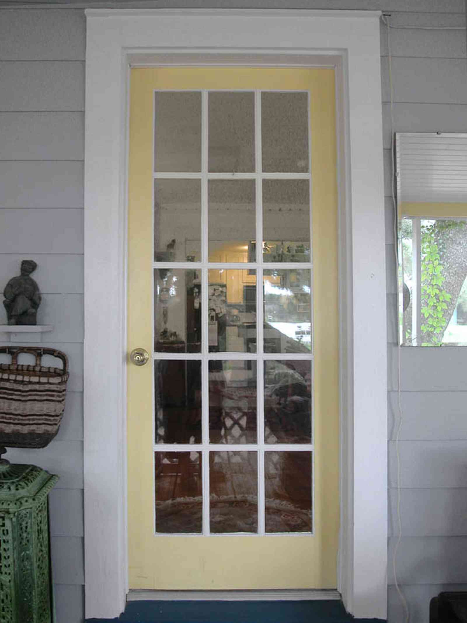 East-Pensacola-Heights:-600-Bayou-Blvd_06.jpg:  front door, front porch, french door, pine lap siding, wicker basket, bayou, cottage