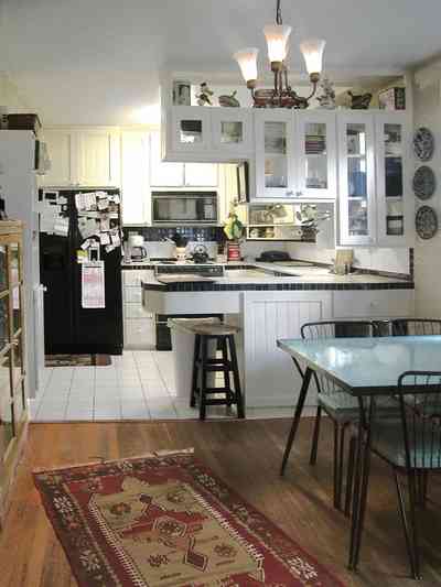 East-Pensacola-Heights:-600-Bayou-Blvd_11.jpg:  glass cabinets, heart pine floors, dining room table, kitchen stool, built-in appliances, white ceramic tile