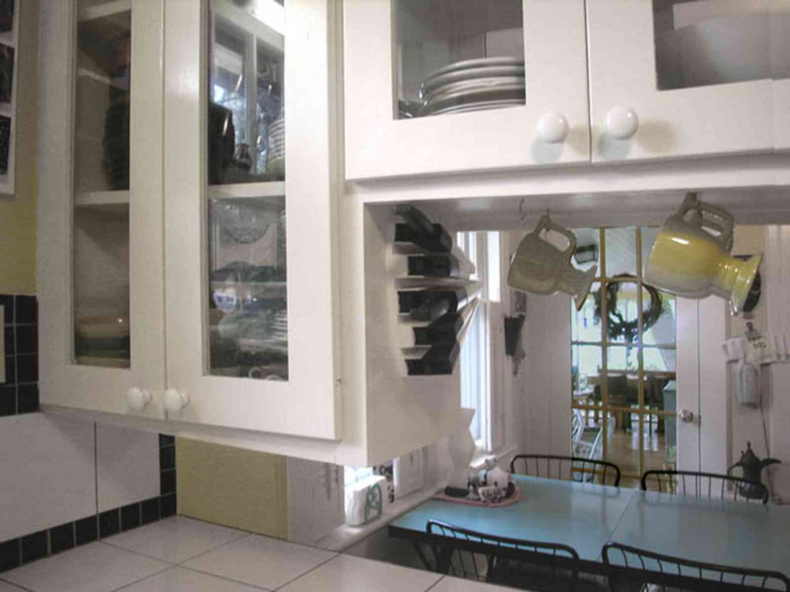 East-Pensacola-Heights:-600-Bayou-Blvd_15.jpg:  glass front cabinets, kitchen, dining area, hanging cups, ceramic tile countertops, screened porch