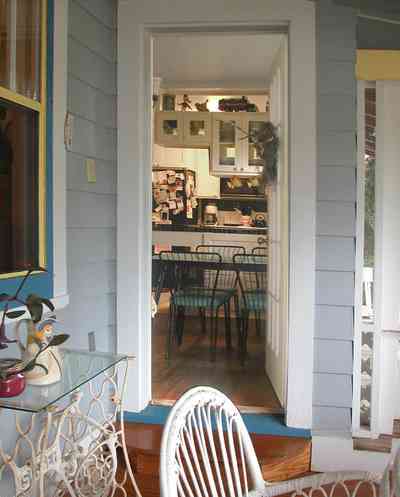 East-Pensacola-Heights:-600-Bayou-Blvd_23.jpg:  screened-in porch, french door, kitchen, dining area, wicker furnture