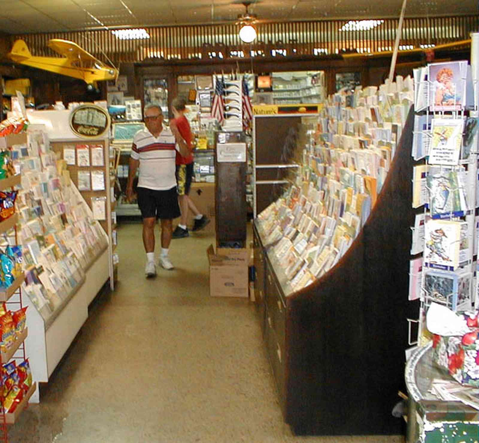 Foley:-Staceys-Drugstore_10.jpg:  drugstore, soda fountain, banana split, glass display cases, soda shop, awning, store front, brick building, art deco architecture, counter, cracker barrel, malts, milkshake, prescription drugs, druggist, card racks