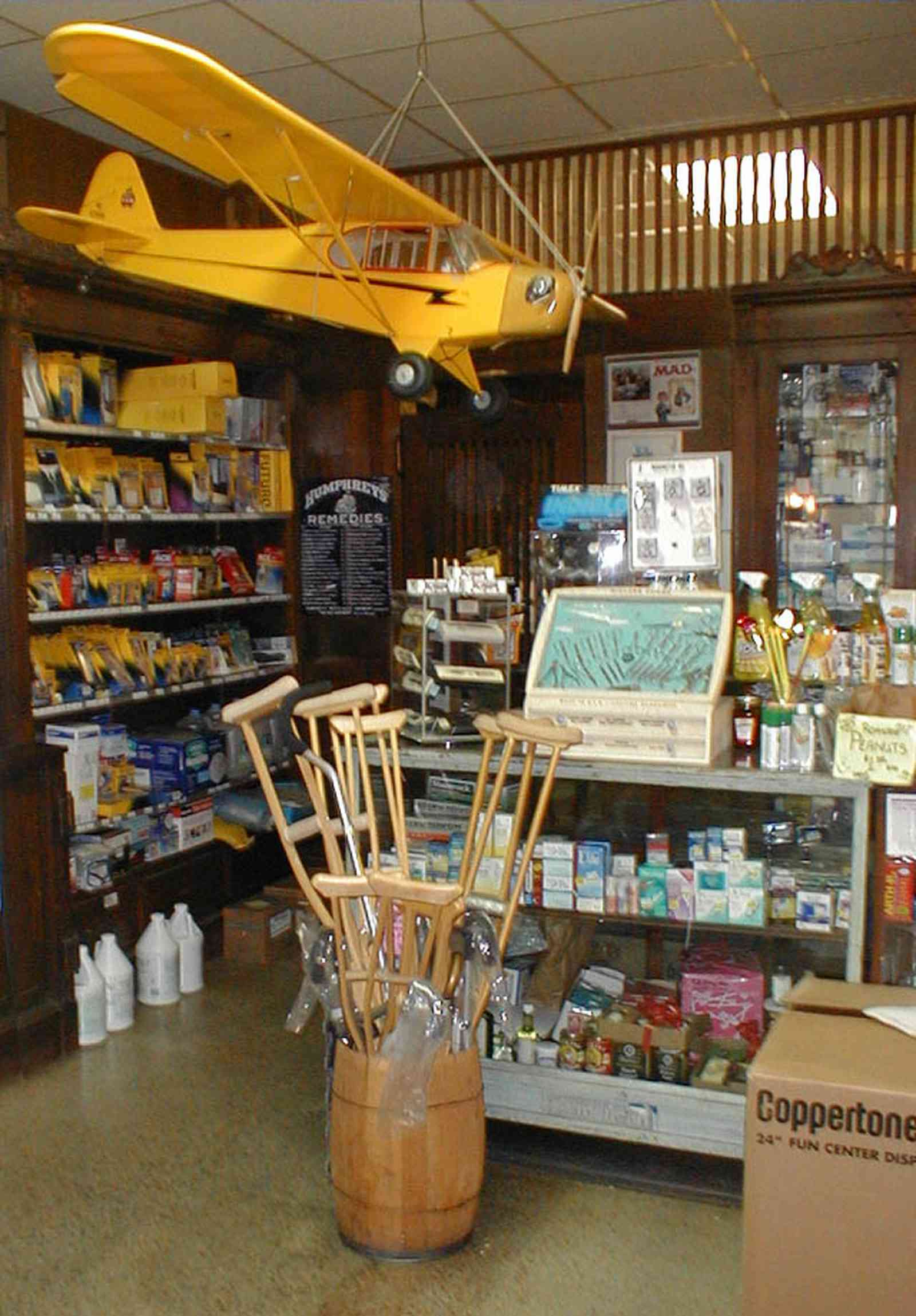 Foley:-Staceys-Drugstore_11.jpg:  drugstore, soda fountain, model-t ford, banana split, glass display cases, soda shop, awning, store front, brick building, art deco architecture, counter, cracker barrel, malts, milkshake, prescription drugs, druggist, card racks