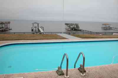 Gulf-Breeze:-228-North-Cliff-Dr_03.jpg:  swimming pool, bay, dock, pier, deck, flag pole, boat, bayfront