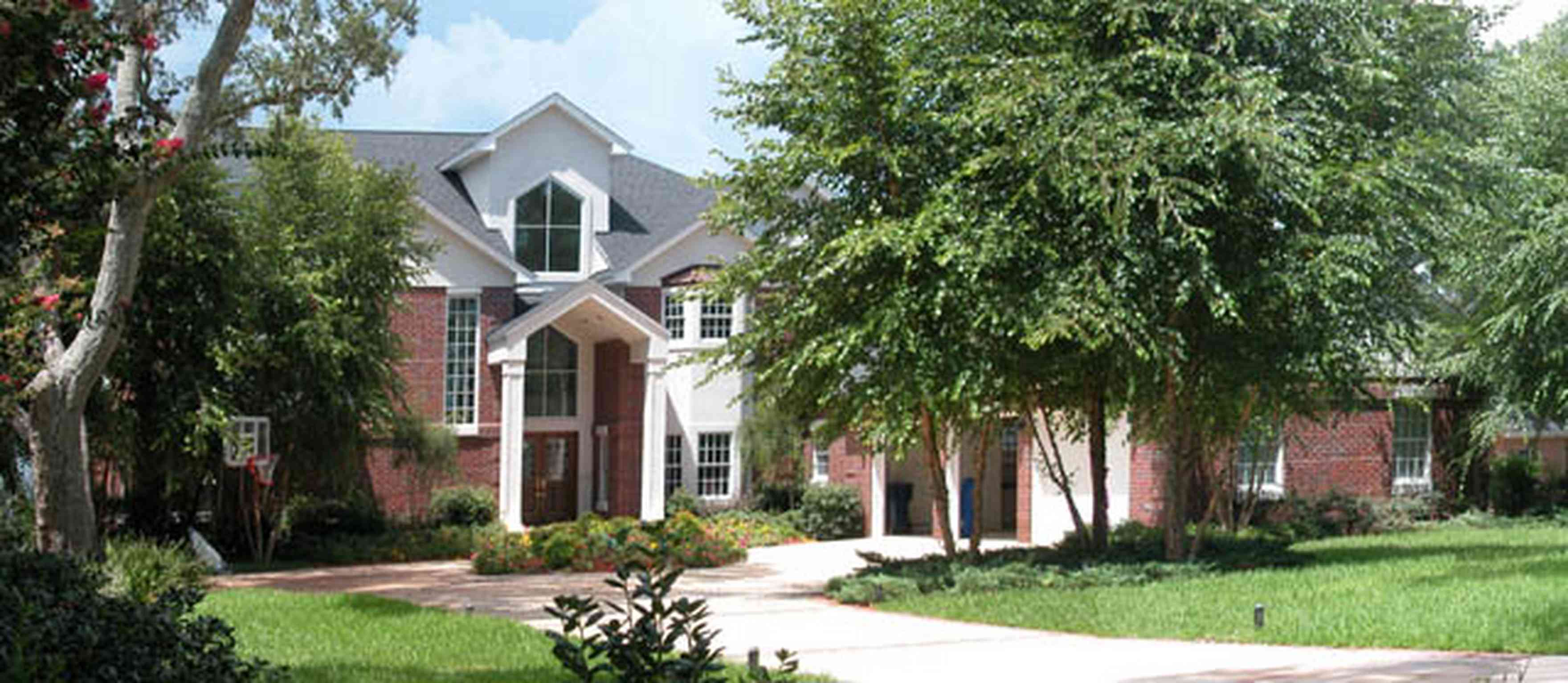 Gulf-Breeze:-706-Fair-Point-Drive_02-copy.jpg:  gate, entrance, formal driveway, lanterns, oak trees, white columns, pediment, birch trees, circular driveway, brick columns