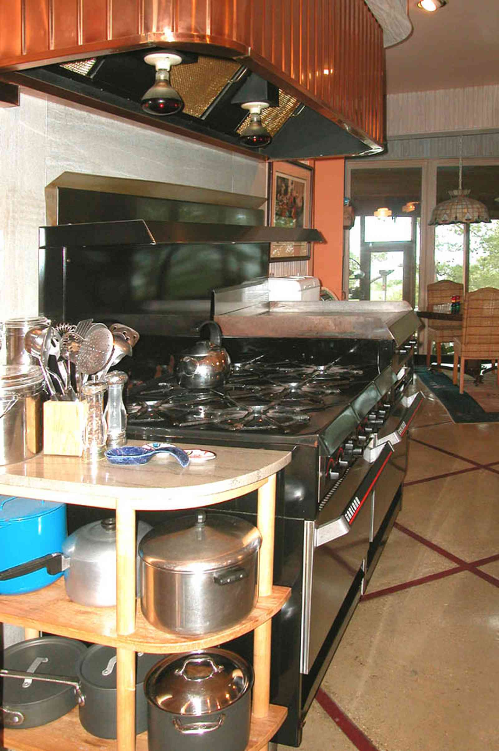 Gulf-Breeze:-92-High-Point-Drive_07.jpg:  copper range hood, restaurant kitchen, copper pots, tile floor, spoon rest, kitchen