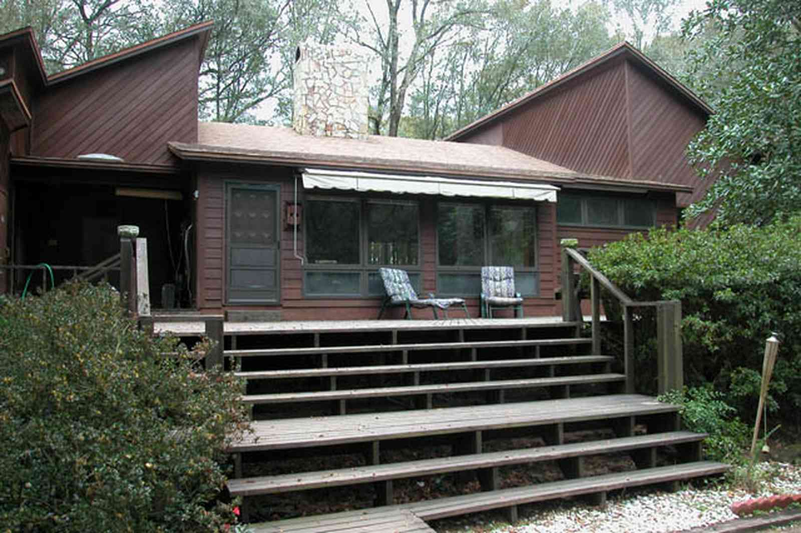 Gulf-Breeze:-9753-Quail-Hollow-Blvd_01.jpg:  deck, steps, awning, 1970's modern home, woods, forest