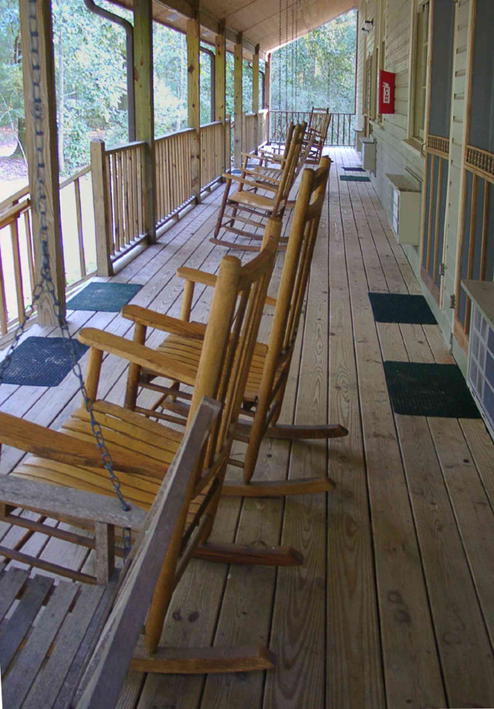 Milton:-Adventures-Unlimited_23.jpg:  porch, rockers, inn, creek, forest, campground