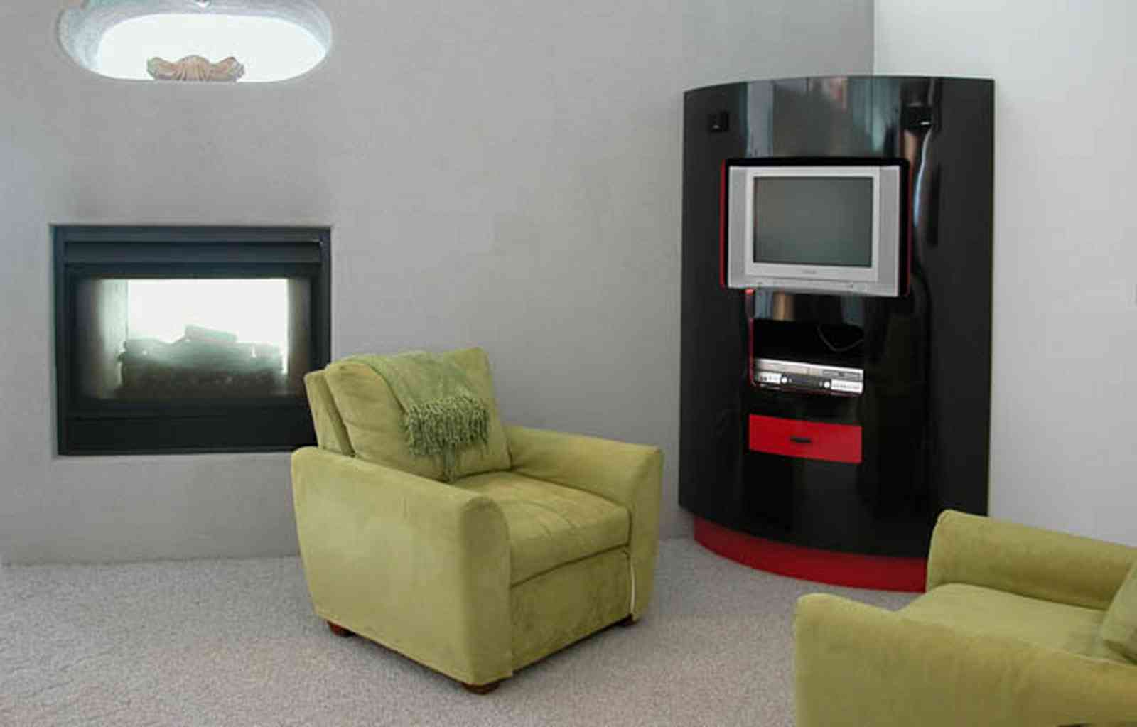 Navarre:-7332-Grand-Navarre-Blvd_29.jpg:  entertainment center, black laquered cabinet, gas log fireplace, green suede chairs, white carpet, art deco house