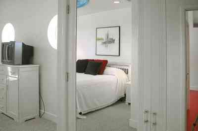 Navarre:-7332-Grand-Navarre-Blvd_35.jpg:  art deco decor, art deco house, bedroom, white carpet, round windows