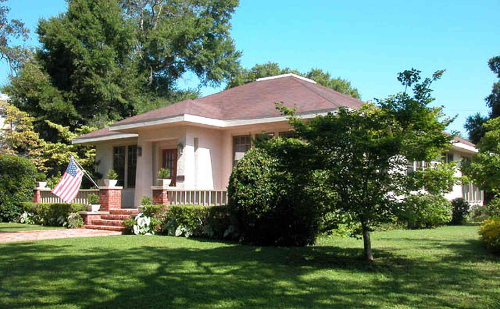 North-Hill:-100-West-DeSoto-Street_02.jpg:  prairie school of architecture, oak tree, american flag, hipped roof, stucco 