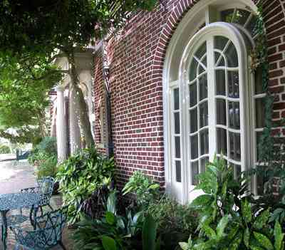 North-Hill:-105-West-Gonzales-Street_02a.jpg:  porch, balcony, oak tree, brick terrace, french colonial architecture, wrought-iron fence