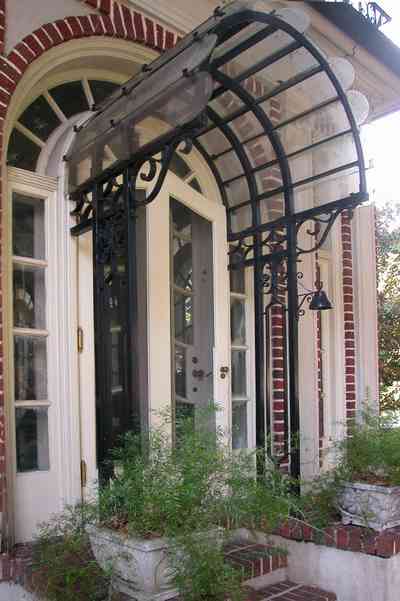 North-Hill:-105-West-Gonzales-Street_09c.jpg:  red brick house, fireplace, sidewalk, wrought iron fence, green tile roof