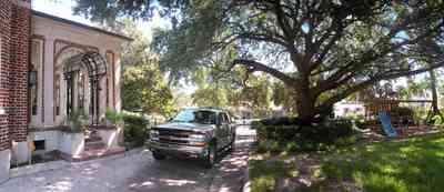 North-Hill:-105-West-Gonzales-Street_10.jpg:  red brick house, fireplace, sidewalk, wrought iron fence, green tile roof