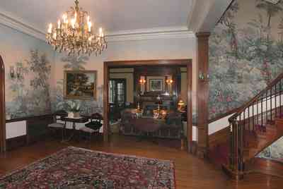 North-Hill:-105-West-Gonzales-Street_25.jpg:  grand foyer, oriental rug, spiral staircase, chandelier, hardwood floors, french colonial architecture