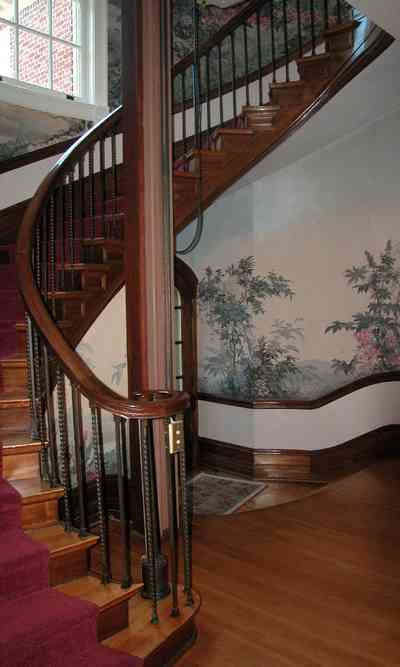 North-Hill:-105-West-Gonzales-Street_29.jpg:  grand foyer, oriental rug, spiral staircase, chandelier, hardwood floors, french colonial architecture, handpainted wallpaper