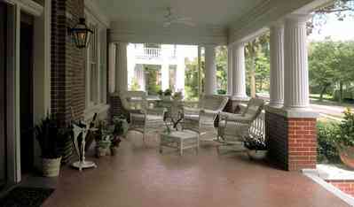 North-Hill:-116-DeSoto-St_02aa.jpg:  white columns, brick pillars, umbrella stand, wicker furniture, hibicus flowers, porch, ceiling fan