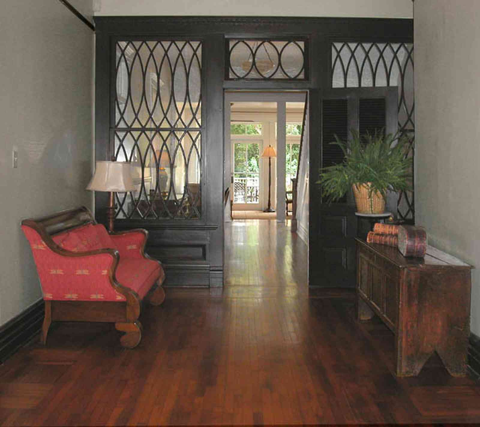 North-Hill:-116-DeSoto-St_02c.jpg:  heartpine floors, entry hall, red sofa, potted fern, central hall