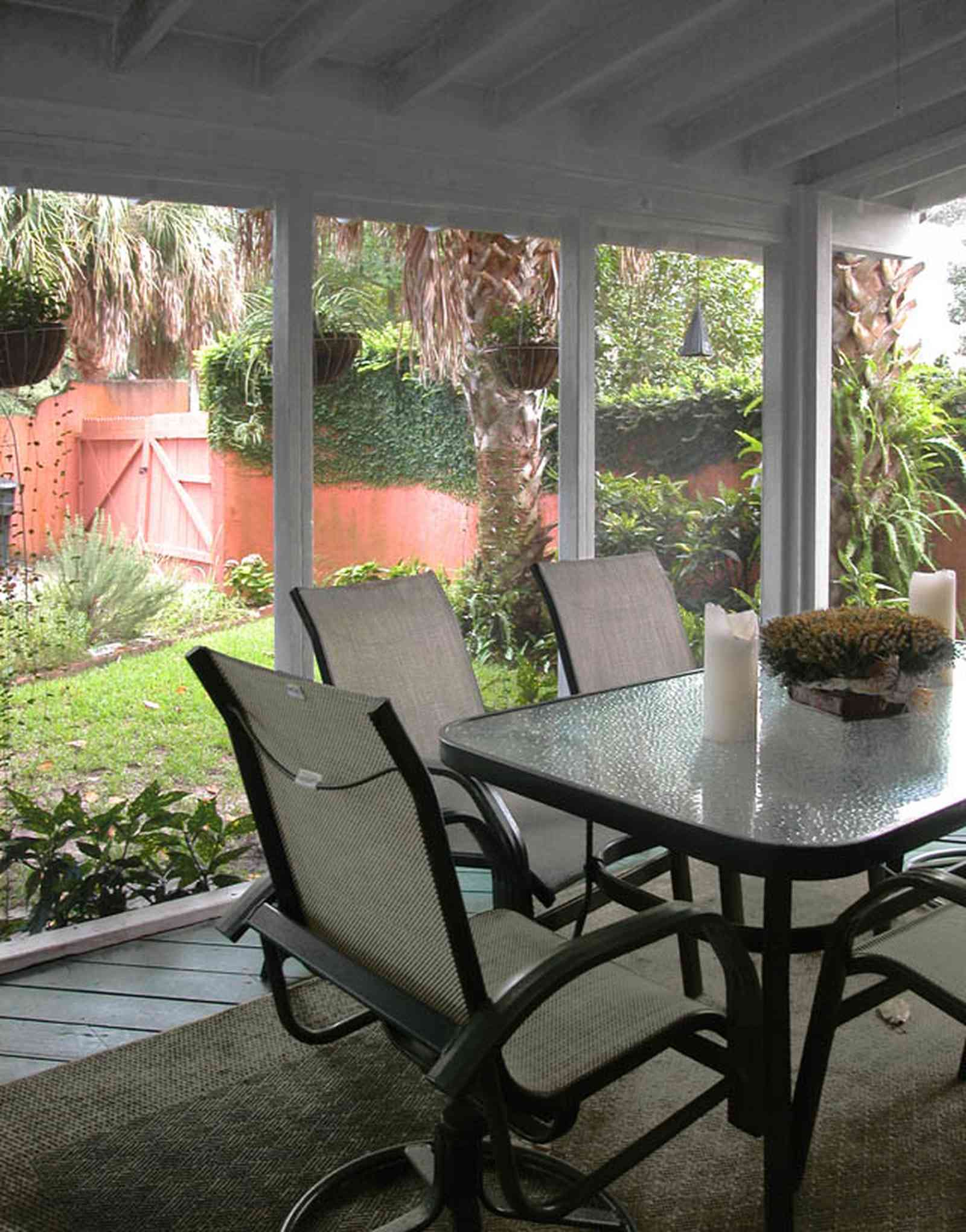 North-Hill:-123-West-Lloyd-Street_25.jpg:  screened porch, stucco walls, vine covered wall, garden gate, garden, backyard, palm trees, glass-top table