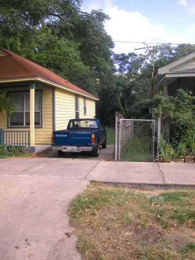 Old-East-Hill:-415-La-Rua-Street_01.jpg:  craftsman cottage, brick street, driveway, oak trees, front porch, chain link fence