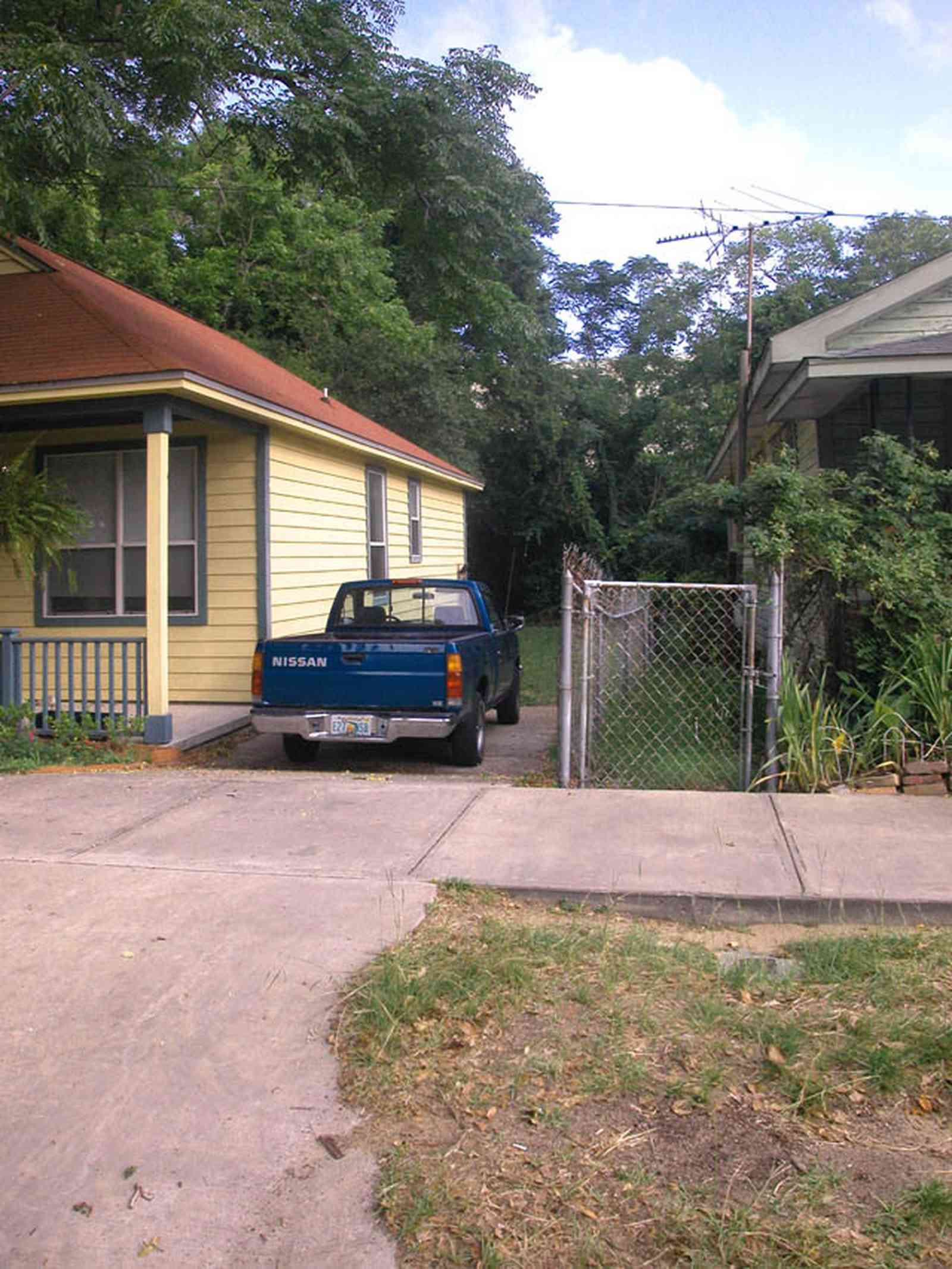 Old-East-Hill:-415-La-Rua-Street_01.jpg:  craftsman cottage, brick street, driveway, oak trees, front porch, chain link fence