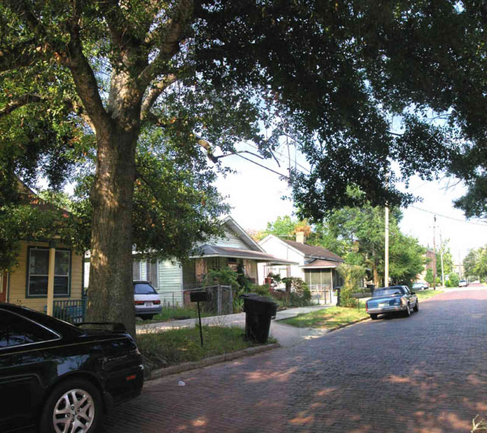 Old-East-Hill:-415-La-Rua-Street_03.jpg:  craftsman cottage, brick street, driveway, oak trees, front porch, chain link fence