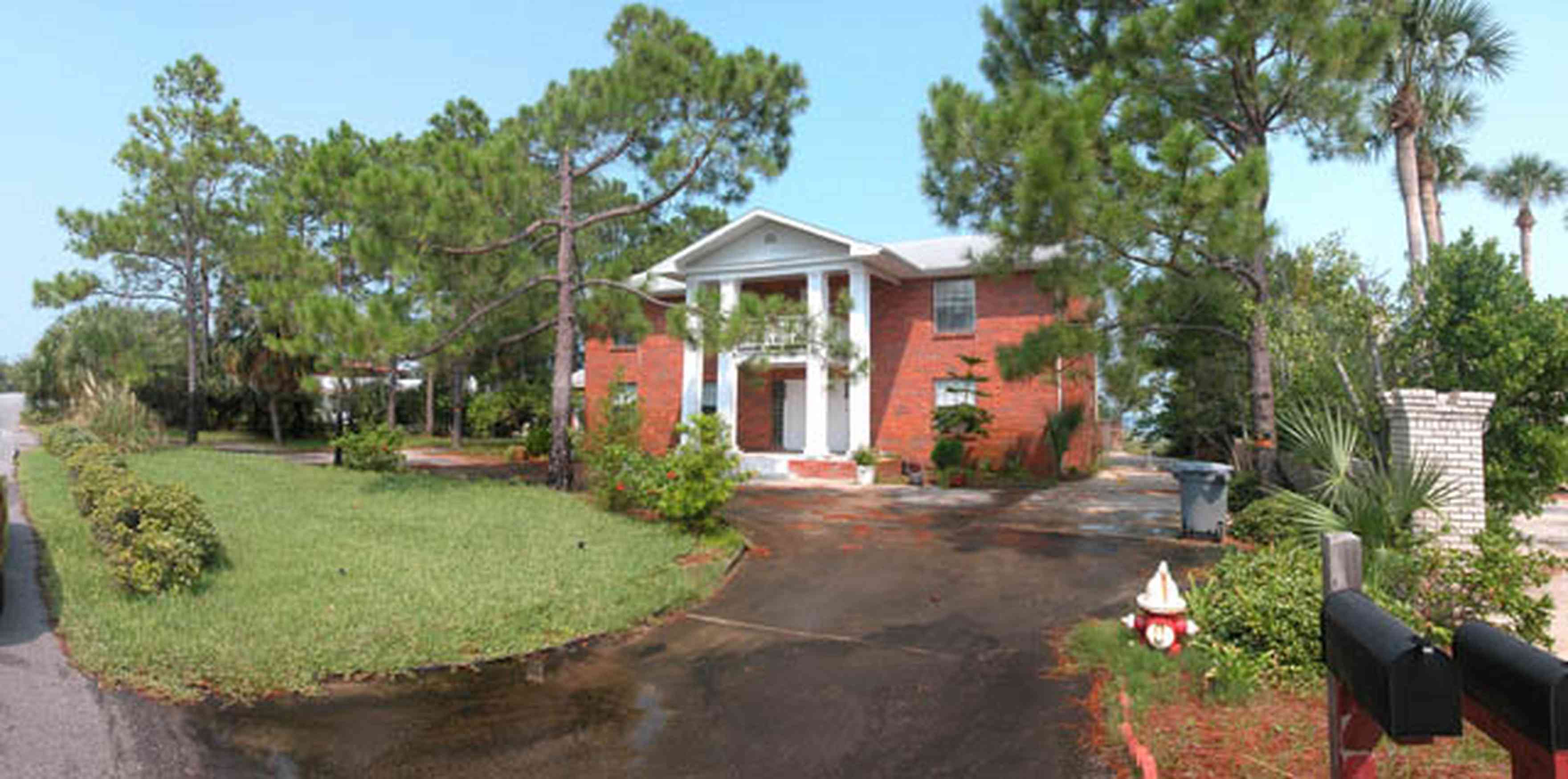 Pensacola-Beach:-235-Sabine-Drive_01.jpg:  colonial architecture, columns, red brick house, pine trees, long-leaf pines, circular driveway