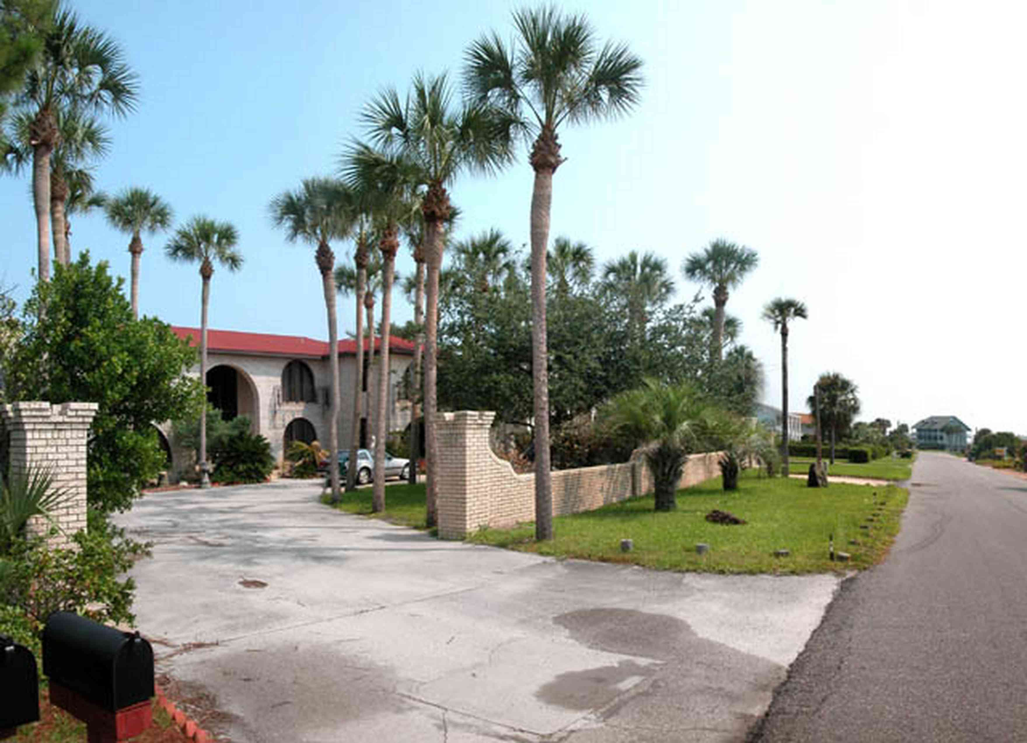 Pensacola-Beach:-237-Sabine-Drive_01.jpg:  meditterean architectural style, 1970's architecture, greek statue, palm tree, circular driveway, brick house