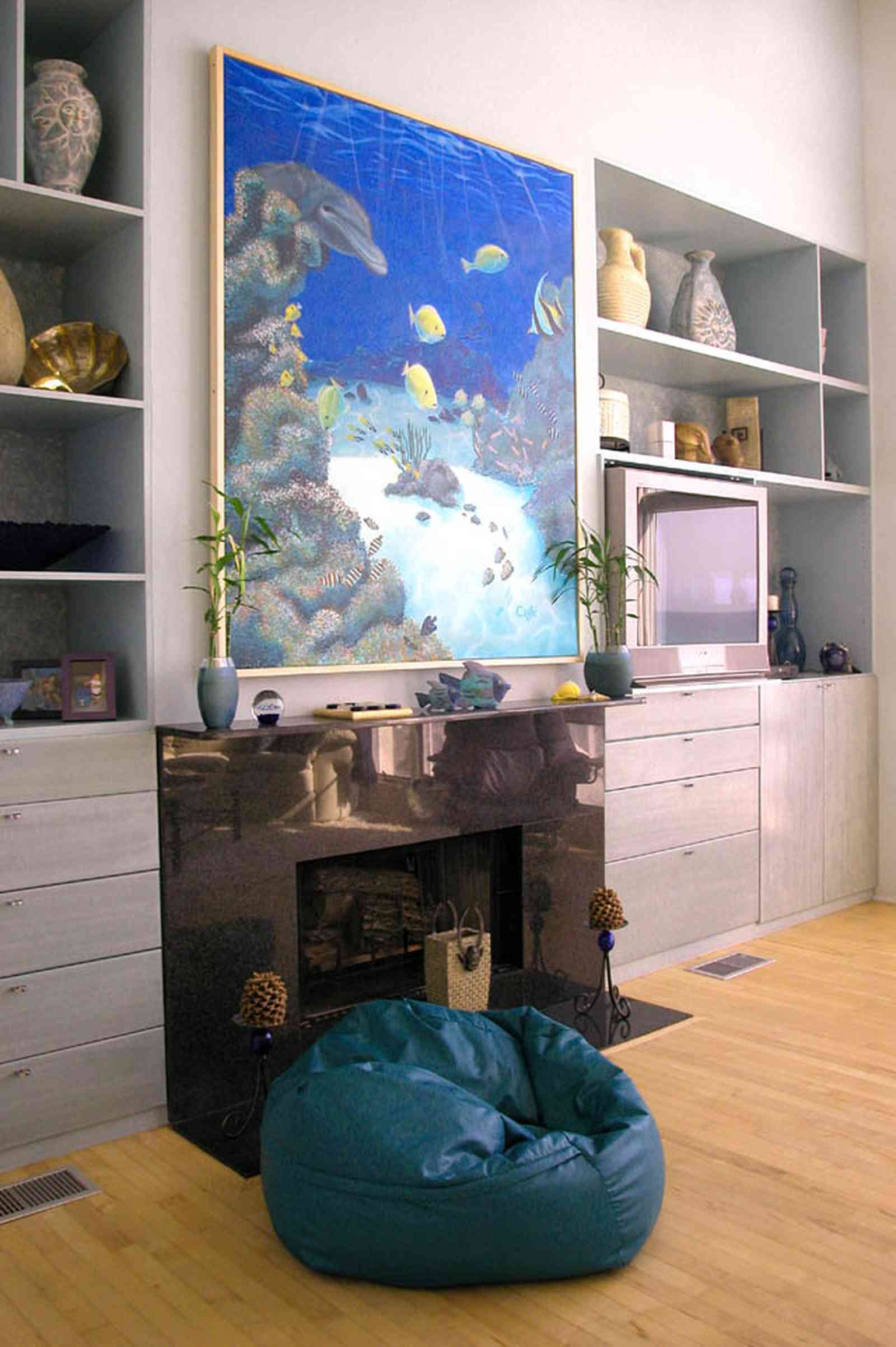 Pensacola-Beach:-Ariola-Drive-Art-Deco-House_29b.jpg:  bean bag chair, marble mantle, tv set, sealife painting, wood floor, built-in shelves, beachfront home, knick-knacks