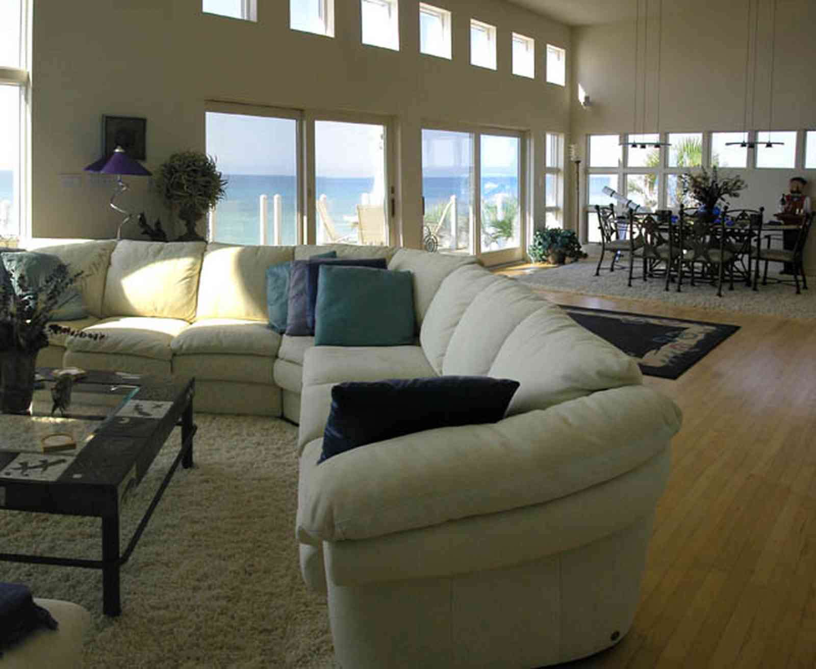 Pensacola-Beach:-Ariola-Drive-Art-Deco-House_32.jpg:  sectional sofa, leather sofa, hassock, beachfront home, coffee table, bar stools, grantite countertop, ceiling fan, patio doors, dining room table, beach