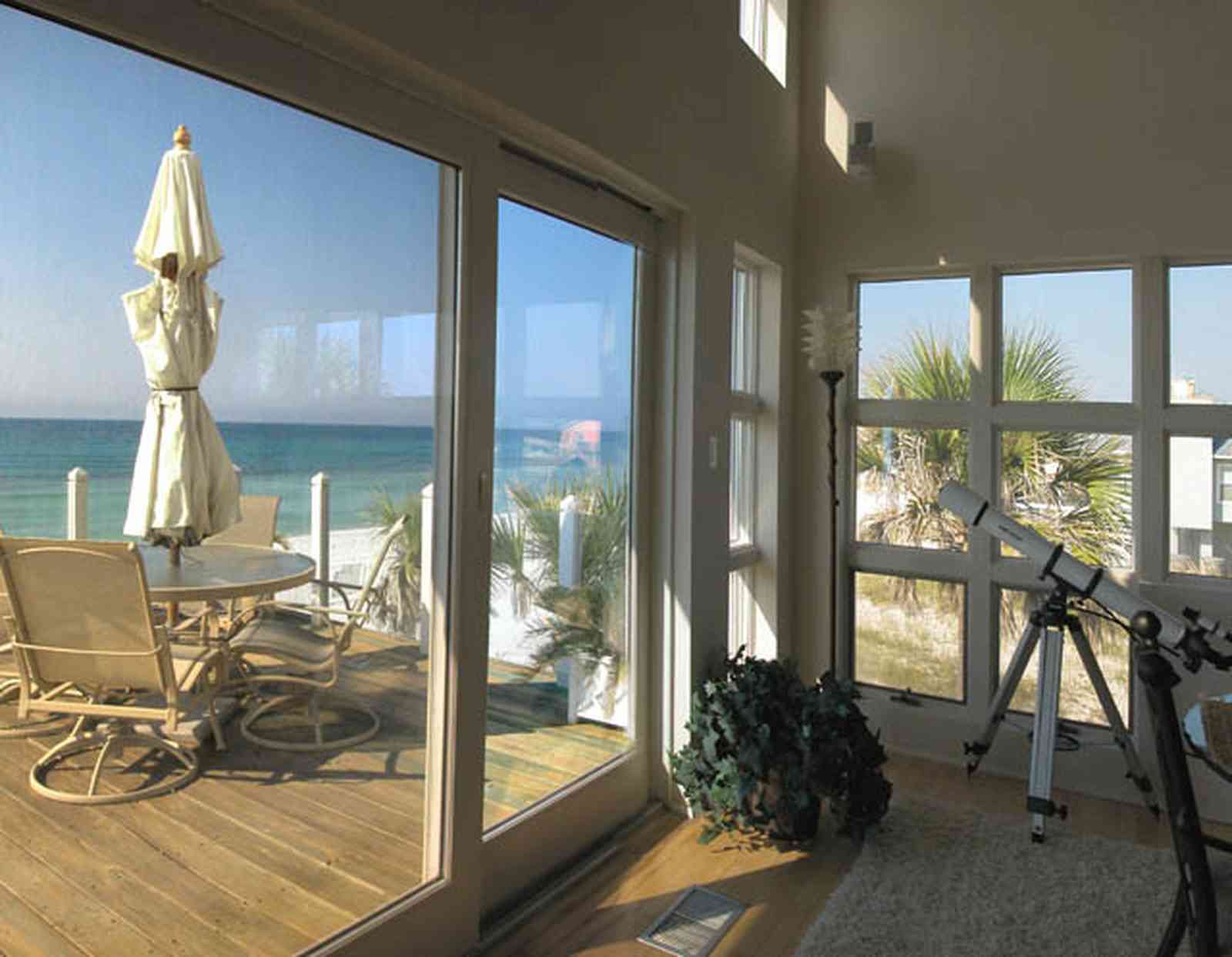 Pensacola-Beach:-Ariola-Drive-Art-Deco-House_33.jpg:  umbrella table, deck, telescope, wood floors, gulf of mexico, windows, palm tree, beachfront view
