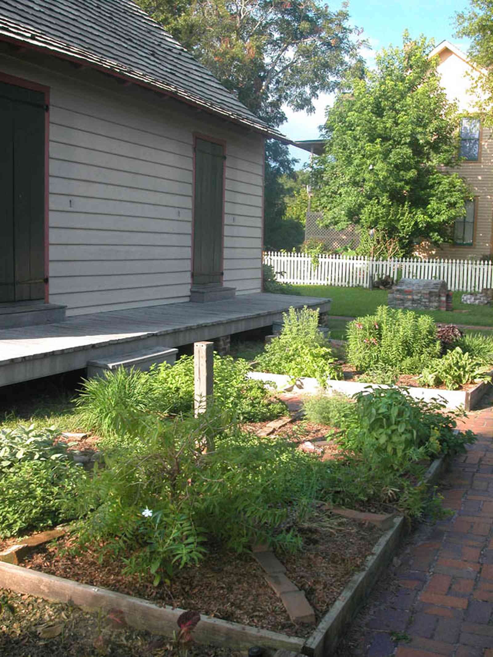 Pensacola:-Historic-Pensacola-Village:-LaValle-House_2c.jpg:  picket fence, wood shingle roof, kitchen garden, spices, herbs, brick sidewalk, basil, oregano, thyme
