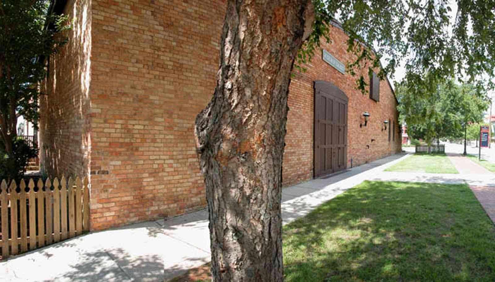 Pensacola:-Historic-Pensacola-Village:-Museum-Of-Commerce_03.jpg:  river birch tree, picket fence, museum, warehouse, historic district
