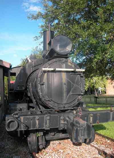 Pensacola:-Historic-Pensacola-Village:-Museum-Of-Industry_04.jpg:  locomotive, caboose, oak tree, picket fence, brick sidewalk