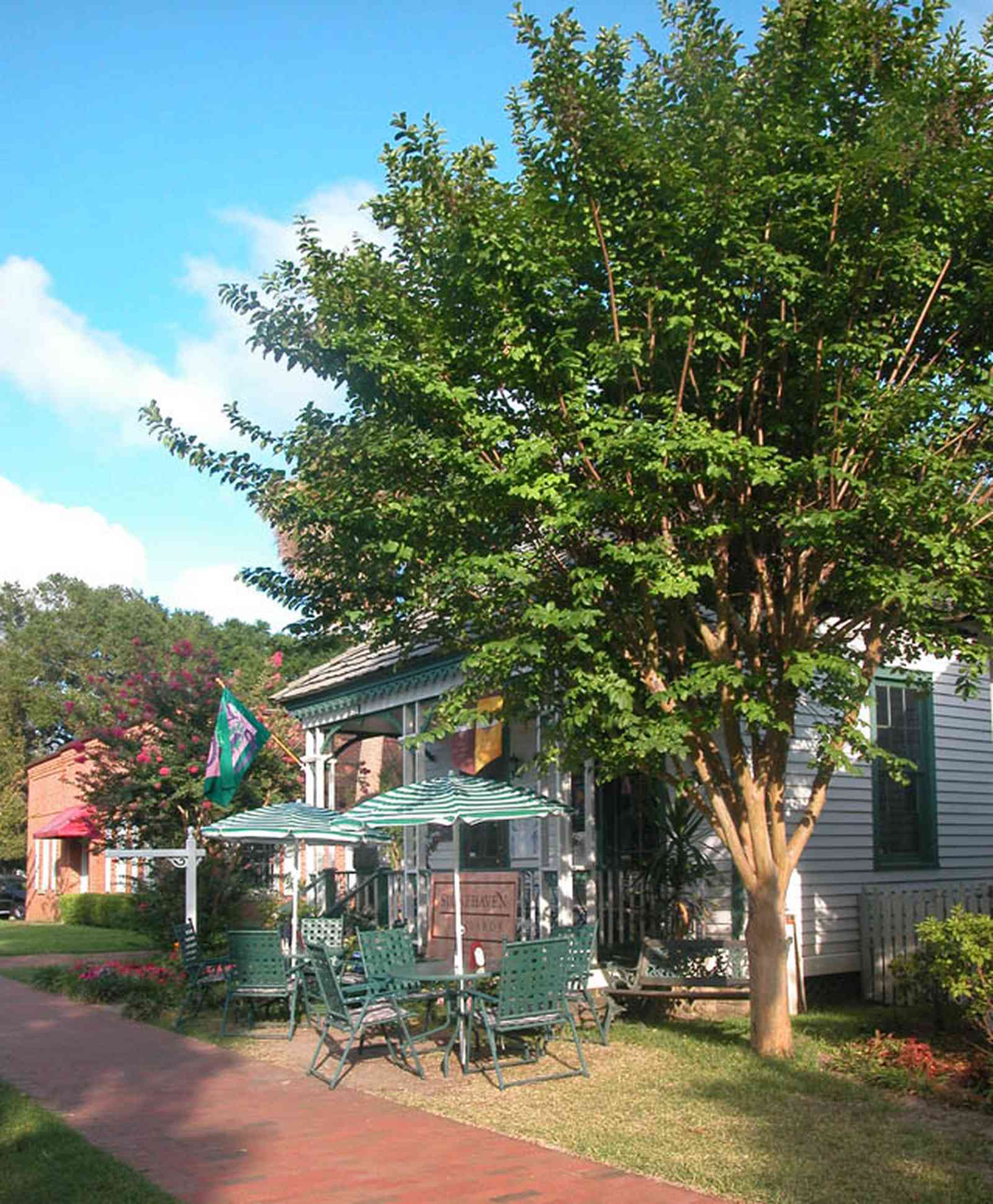 Pensacola:-Historic-Pensacola-Village:-The-Moreno-Cottage_03.jpg:  cafe, victorian cottage, shotgun cottage, crepe myrtle tree, umbrella table, brick sidewalk, cedar shake roof