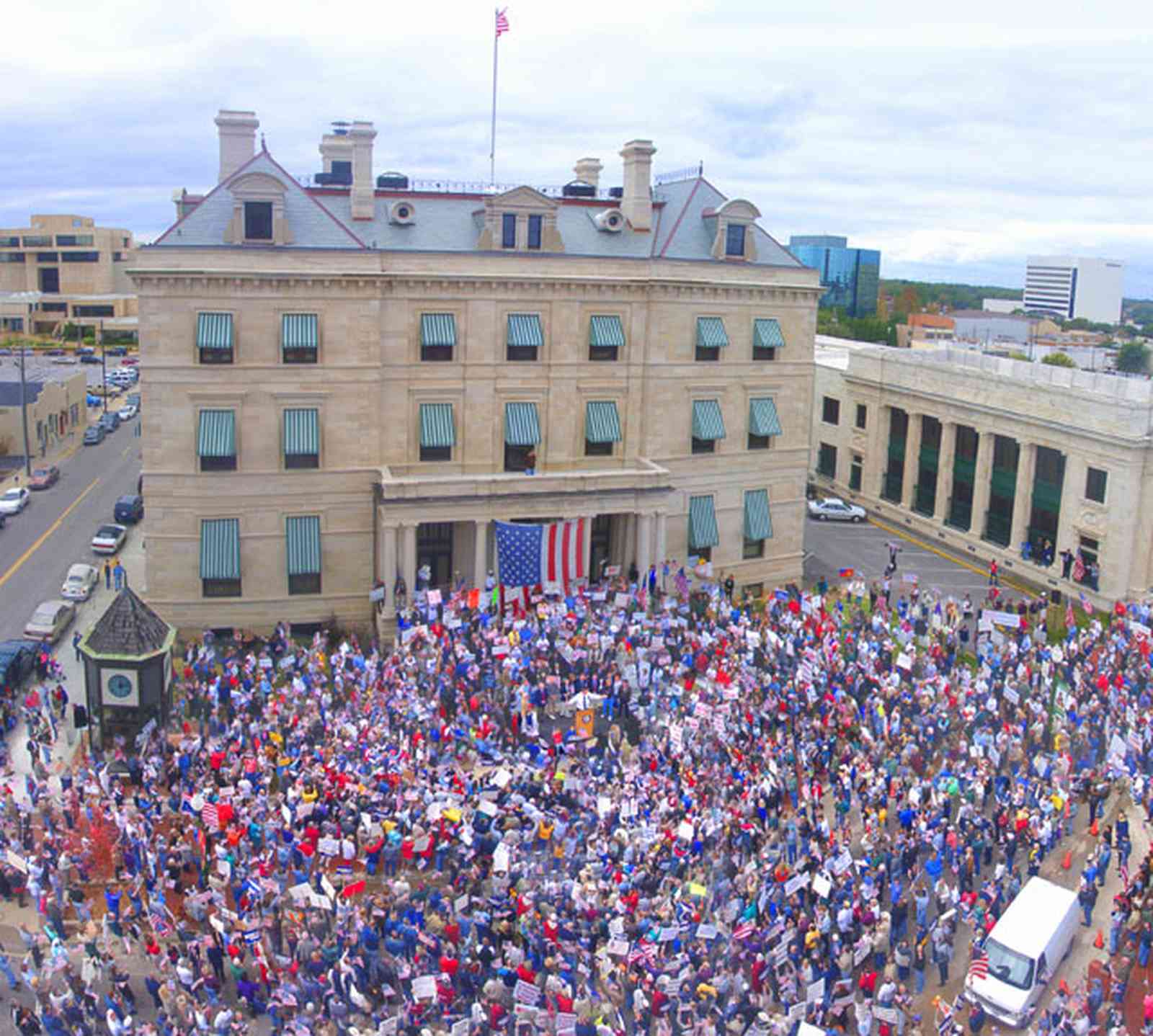 Pensacola:-Palafox-Historic-District:-Escambia-County-Courthouse_01.jpg:  escambia county courthouse, rally, awnings, renaissance revival architecture, american flag, crowd