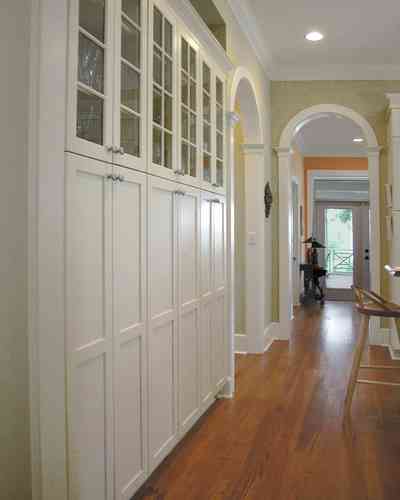 Pensacola:-Seville-Historic-District:-202-Cevallos-Street_14.jpg:  heart pine flooring, kitchen cabinets, hall, arcade, arched doorway, columns, storage space